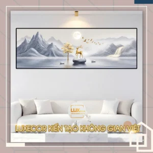 Bức tranh tráng gương hươu vàng núi non xám bạc phong thủy treo trên sofa trắng hiện đại.